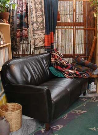 a brown leather couch with throws